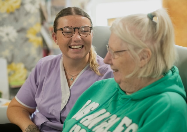 nurse with resident in care home smiling