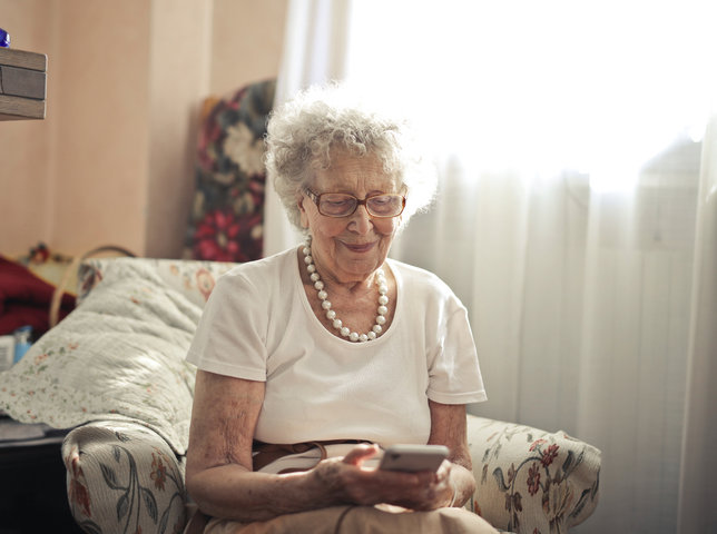 older woman smiling at her phone