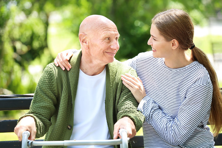 man with zimmer frame looking at family member